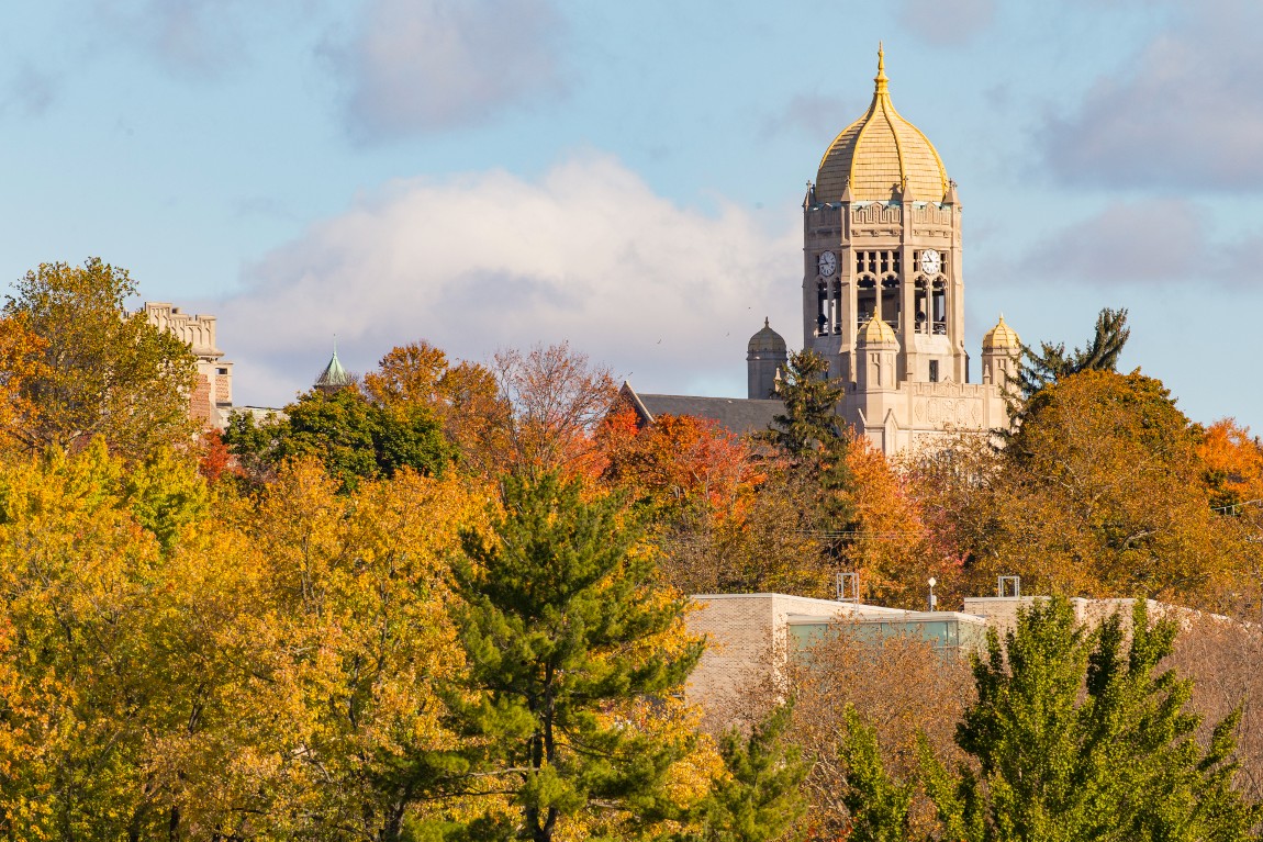 A picture of Haas Bell Tower among trees with fall foliage
